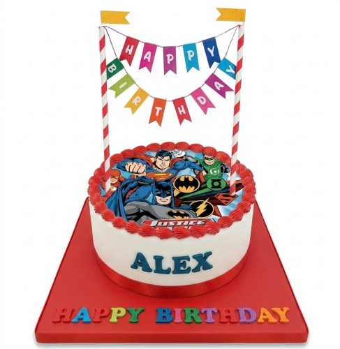 Round white Justice League birthday cake with Batman, Superman, Flash, Green Lantern, red piping, and a Happy Birthday banner.
