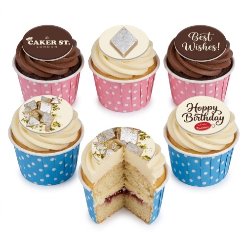 Selection of Indian Inspired Birthday Cupcakes with Kaju Katli, pistachio, 'Happy Birthday', 'Best Wishes', and brand logo toppers, in pink and blue polka dot cases.