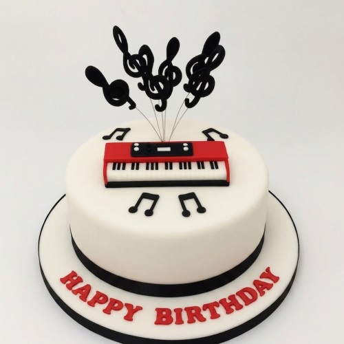 White round cake with red keyboard, black musical notes, and treble clef toppers.