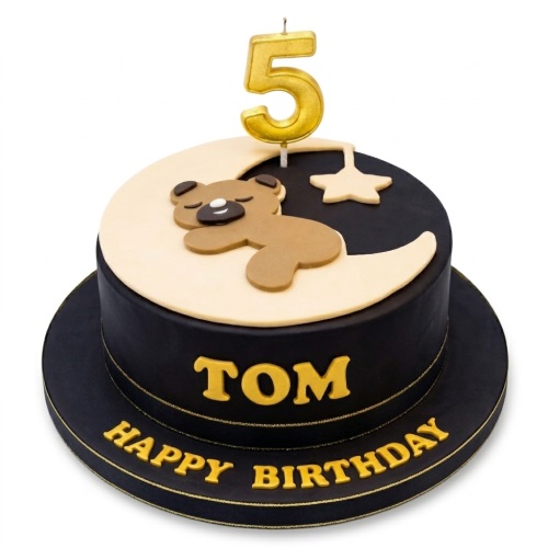 Round black and cream cake with a sleeping teddy bear on a moon, stars, and a custom age candle.
