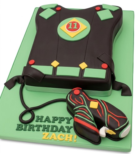 Laser tag vest and phaser birthday cake on a green board with custom age and message.