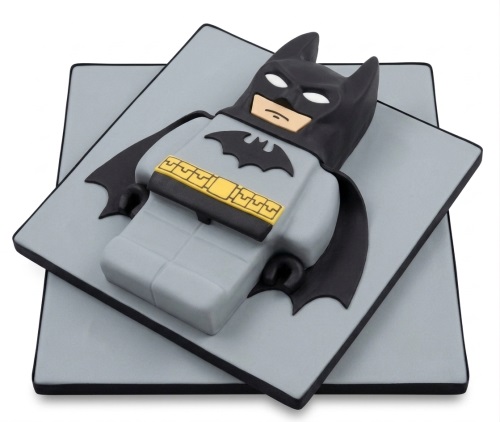 3D Lego Batman shaped birthday cake in grey, black, and yellow colours.