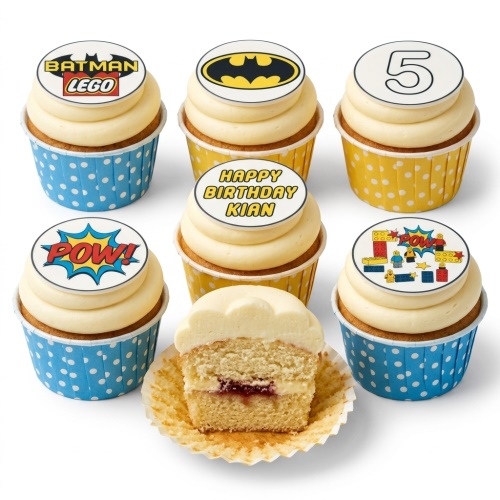 Lego Batman and superhero themed cupcakes with 'POW!' and building block toppers, in blue and yellow polka dot cases.