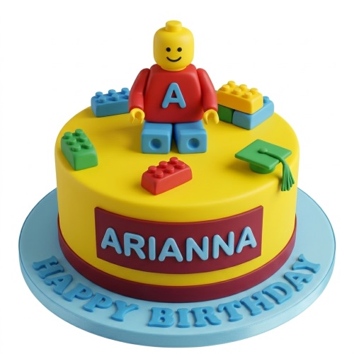 Yellow round cake with a Lego-style figure, colourful building blocks, and a green graduation cap. Personalised name on the side and 'Happy Birthday' on the board.