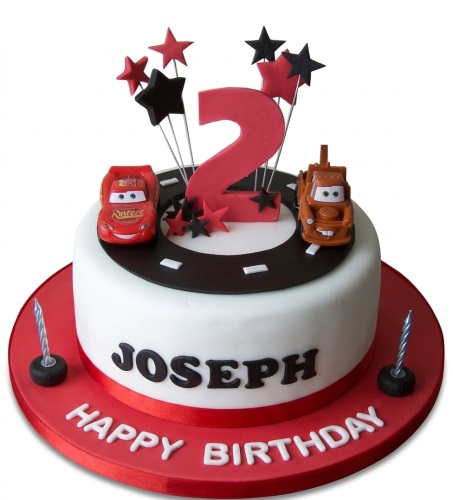 Round white and red Disney Cars theme birthday cake with Lightning McQueen, Mater, red number topper, and stars.