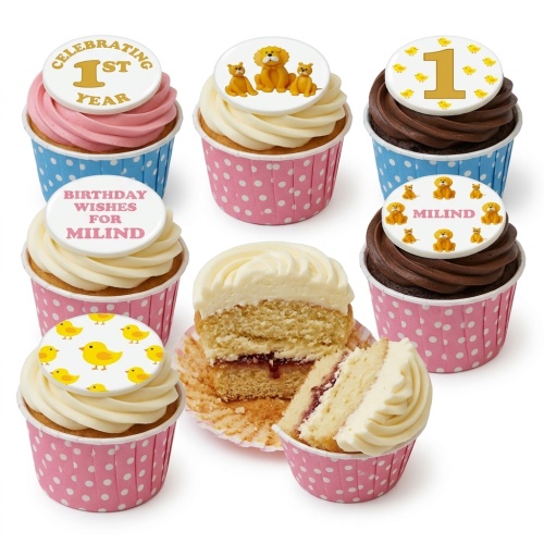 Assortment of 1st birthday cupcakes with lion, chick, and custom age/name toppers in pink and blue polka dot wrappers.