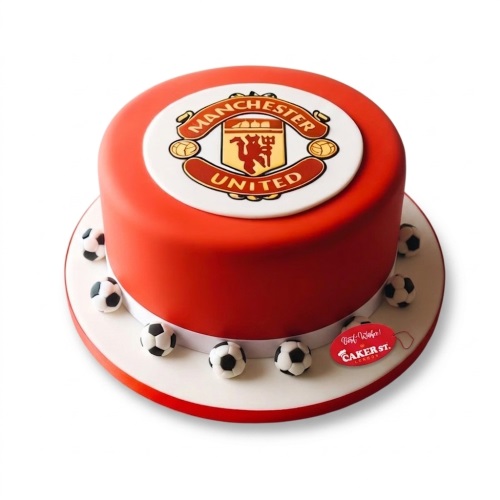 Red round cake with Manchester United logo and small football decorations.