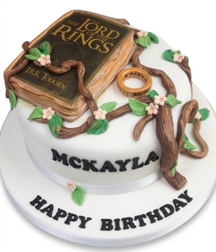 White round Lord of the Rings themed birthday cake with edible book, golden ring, and vine decorations.