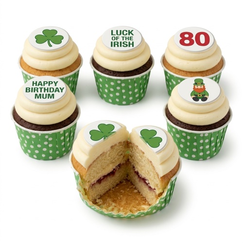 Six cupcakes with green polka dot wrappers, white icing, and edible toppers featuring shamrocks, a leprechaun, and custom messages.