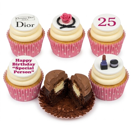 Six cupcakes with cream frosting, pink polka dot cases, and fashion-themed toppers including a rose, makeup, and custom age.
