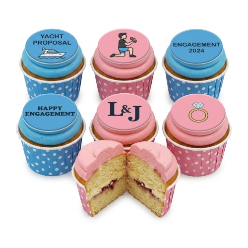 A selection of pink and blue engagement themed cupcakes with proposal, ring, and initial toppers.