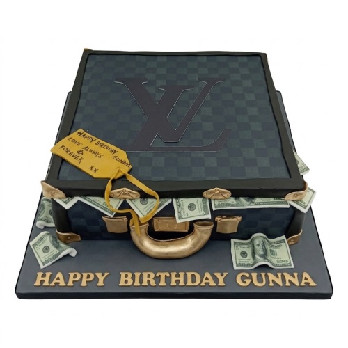 Designer briefcase cake with gold handle, clasps, edible dollar bills, and a custom message tag.