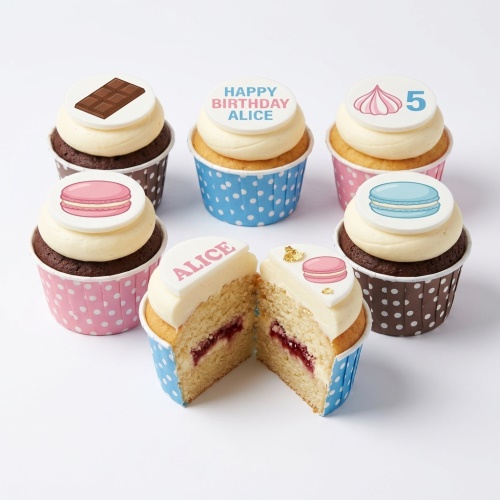 Assorted kids birthday cupcakes with sweet treat toppers, including macarons, chocolate, and meringue, with a custom age and personalised message.
