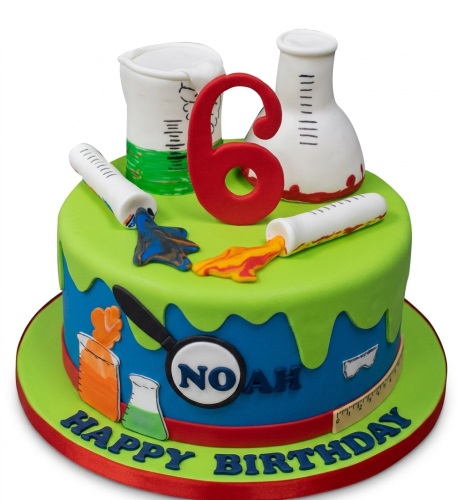 Round green and blue science experiment birthday cake with fondant lab equipment and custom age topper.