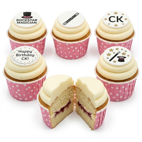 Magician birthday cupcakes with top hat, magic wand, and star decorations on white frosting in pink polka dot cases.