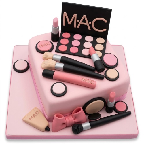 Pink square cake decorated with edible MAC eyeshadow palette, lipsticks, brushes, and compacts.
