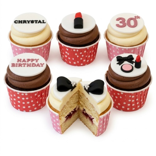 Assortment of birthday cupcakes with makeup, bows, and custom age toppers.
