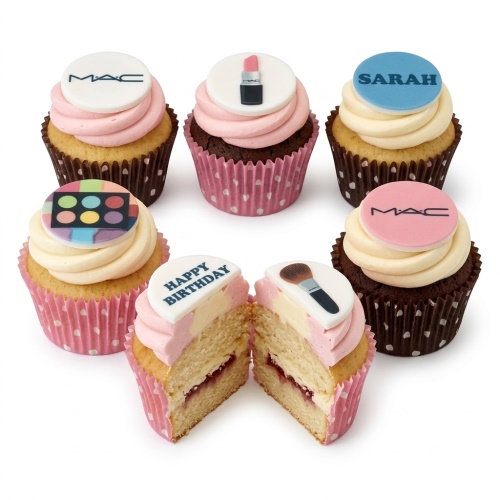 Vanilla and chocolate cupcakes with pink and white frosting, topped with MAC logo, lipstick, eyeshadow palette, makeup brush, and custom message toppers.