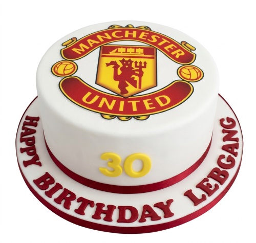 Round white cake with Manchester United logo, red ribbon, custom age topper, and personalised birthday message.