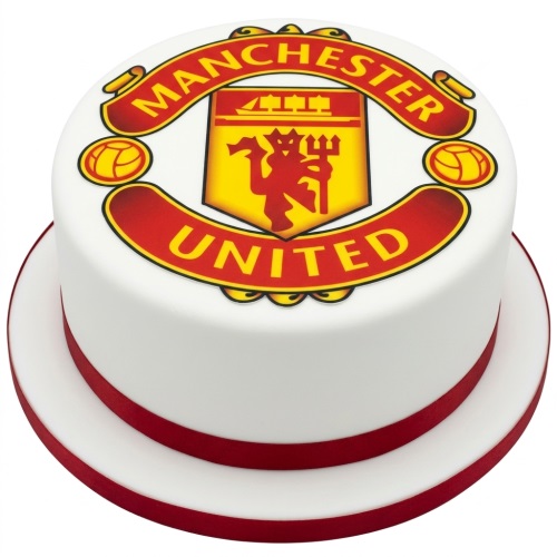 Round white cake with a large Manchester United football club crest and red ribbon.