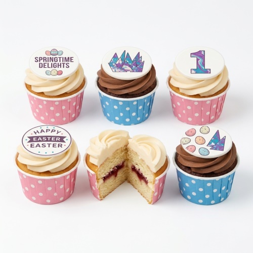 Selection of Easter cupcakes with white and chocolate frosting, decorated with Easter eggs, geometric patterns, and a number 1 topper, in pink and blue polka dot cases.