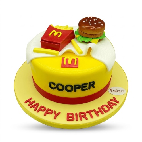Yellow and red fast food theme birthday cake with edible burger, fries, and 'M' logos.