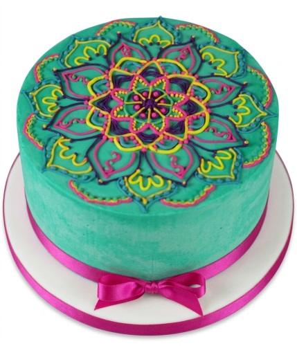 Round teal cake with intricate pink, yellow, purple mandala design and fuchsia ribbon.