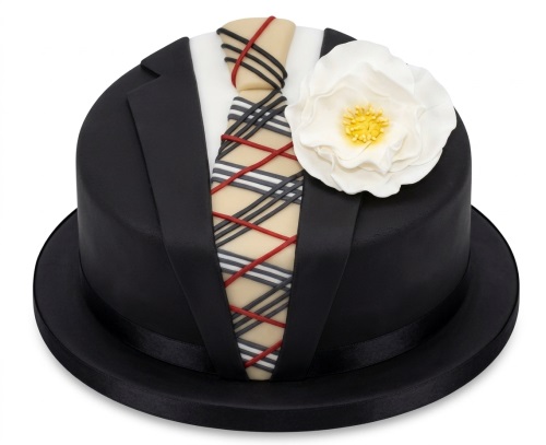 Round black suit birthday cake with a patterned tie and white flower.