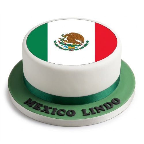 Round white cake with Mexican flag on top, green ribbon, and 'Mexico Lindo' on the board.
