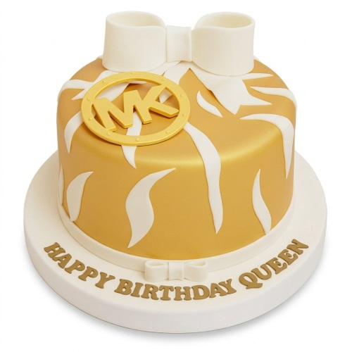 Gold and white designer birthday cake with a brand-inspired logo and a white bow.