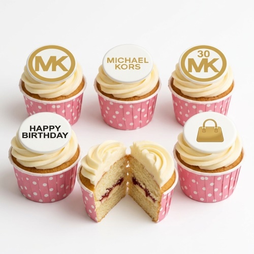 White and gold Michael Kors themed cupcakes in pink polka dot wrappers with custom age and Happy Birthday toppers.