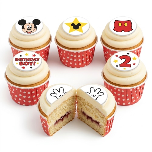 A selection of Mickey Mouse themed birthday cupcakes with red polka dot wrappers and various edible toppers including Mickey's face, shorts, hands, a star with Mickey's silhouette, and a number 2 and 'Birthday Boy!' message.