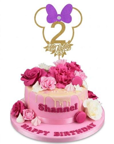 Pink Minnie Mouse themed birthday cake with a gold glitter age topper, sugar flowers, and white drip icing.