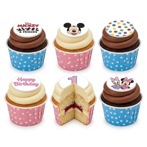 A selection of Disney Mickey Mouse and Friends themed cupcakes with chocolate and vanilla frosting, blue and pink polka dot wrappers, and edible toppers including Mickey Mouse, Minnie Mouse, Daisy Duck, a 'Happy Birthday' message, and a number '1'.