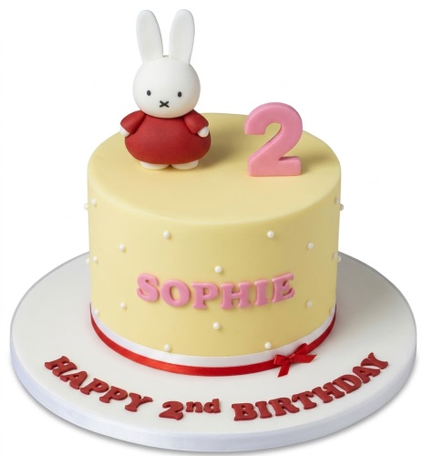 Round yellow Miffy birthday cake with Miffy figurine, pink custom age topper, and red ribbon.