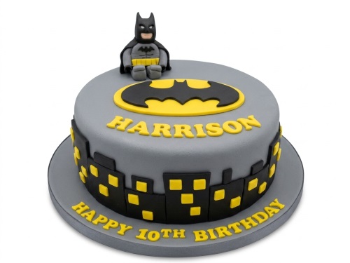 Round grey Batman themed birthday cake with a Batman figurine, bat symbol, cityscape, and custom age and name.