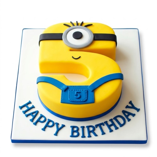 Yellow number 5 cake decorated as a Minion with a goggle and blue overalls, on a white board with 'Happy Birthday' text.