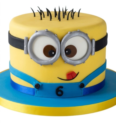 Yellow Minion birthday cake with silver goggles, black hair, blue suspenders, and a custom age number.