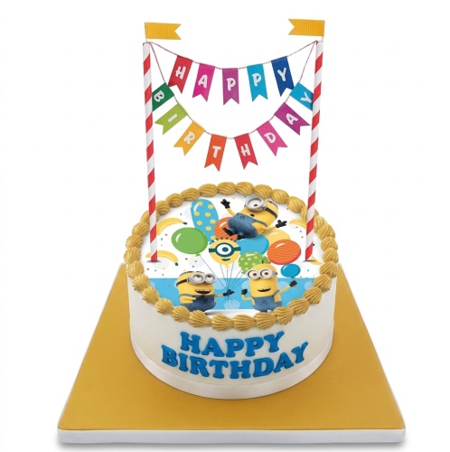 Round white Minions birthday cake with edible character image, balloons, and 'Happy Birthday' banner.