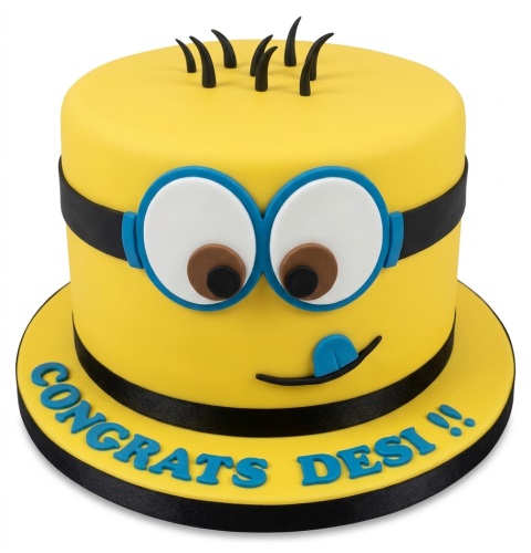 Yellow Minion character birthday cake with goggles, black hair, and a tongue sticking out.