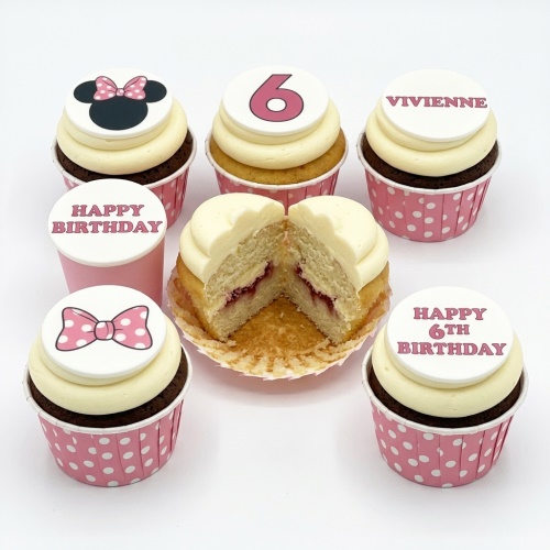 Minnie Mouse themed birthday cupcakes with pink bows and custom age topper.