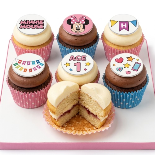 Minnie Mouse themed birthday cupcakes with custom age and Happy Birthday toppers, in pink and blue cases.