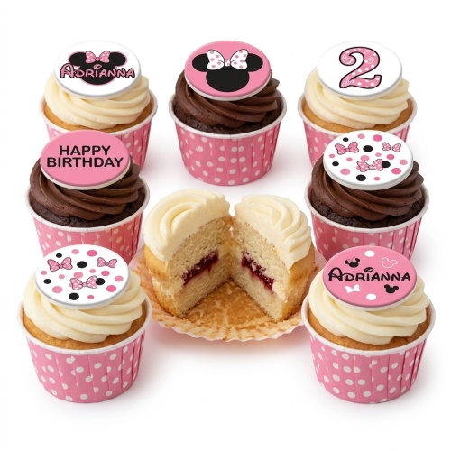 Minnie Mouse themed cupcakes with pink polka dot cases, vanilla and chocolate frosting, and edible toppers including Minnie Mouse bows, a custom age '2', and a personalised name 'Adrianna'.
