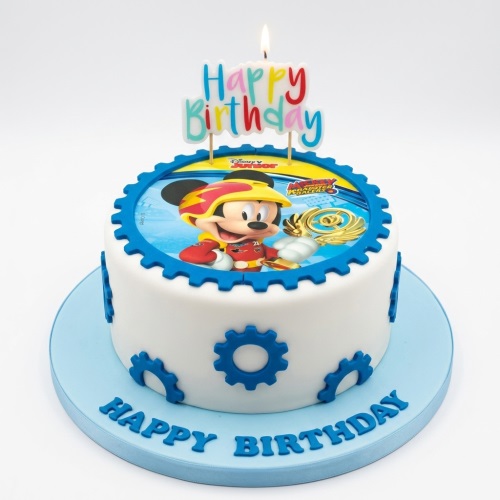 Round white birthday cake with Mickey Mouse Roadster Racers edible image and blue gear decorations.