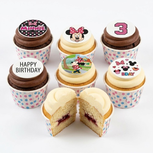 Assortment of Minnie Mouse themed birthday cupcakes with vanilla and chocolate frosting, featuring various Minnie Mouse edible toppers, a number '3' topper, and a 'Happy Birthday' message.