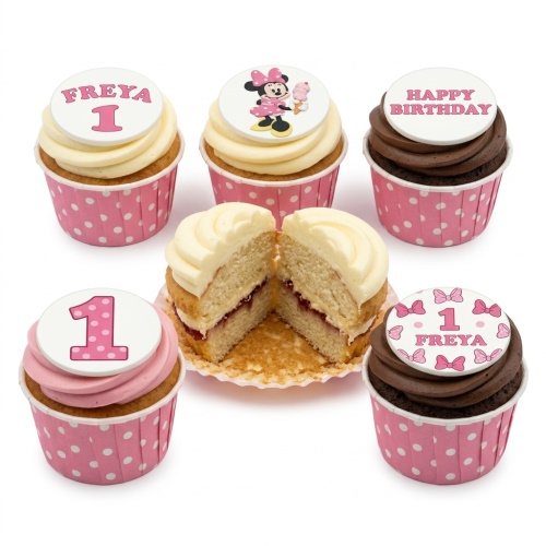 Minnie Mouse themed cupcakes with pink and white frosting, polka dot wrappers, and number 1 topper.