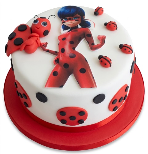 Round white cake with an edible image of Miraculous Ladybug and 3D fondant ladybug decorations.