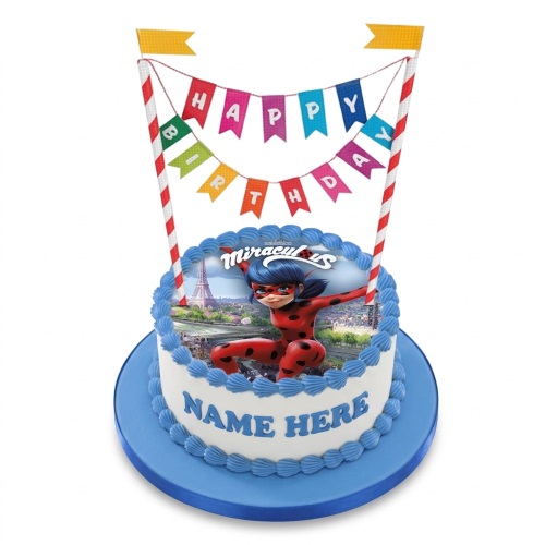 Round white Miraculous Ladybug birthday cake with blue icing and 'Happy Birthday' banner.