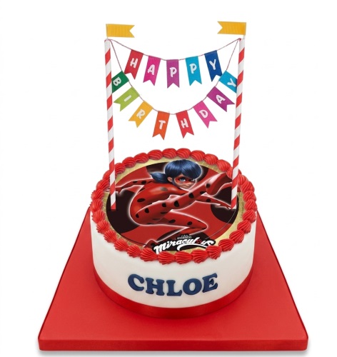 Round white Miraculous Ladybug birthday cake with red frosting, edible Ladybug image, "Happy Birthday" banner, and custom name.
