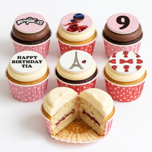 Miraculous Ladybug themed birthday cupcakes with custom age and name toppers, Eiffel Tower, and red bows.